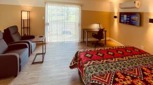 1 dormitorio con cama, sofá y escritorio en White Orchid Apartments en Fort Myers
