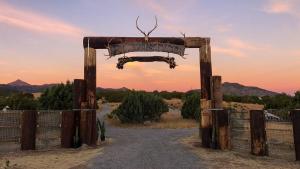 einen Eingang zu einem Zaun mit einem Schild darauf in der Unterkunft Silver Bullet Airstream, El Mistico Glamping Ranch in Nogal
