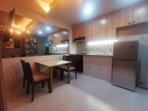 a kitchen with a table and chairs and a refrigerator at Naga City Stylish Condo in Naga