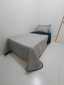 Posto letto in una camera bianca con telaio del letto. di Naga City Stylish Condo a Naga