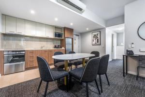 a kitchen and dining room with a table and chairs at Hudson Parap in Darwin