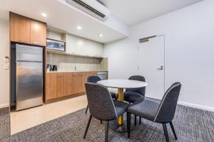 a kitchen with a table and chairs and a refrigerator at Hudson Parap in Darwin