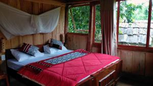 1 dormitorio con 1 cama con edredón rojo y 2 ventanas en Ngoc Chien Pearl, 