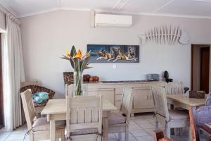 a dining room with a table with a vase of flowers at African Dreamz Guest House in St Lucia