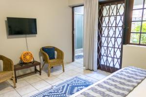 a bedroom with a bed and a tv and a door at African Dreamz Guest House in St Lucia