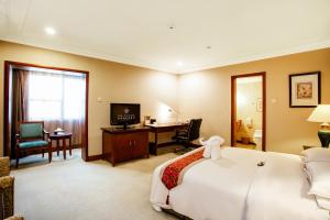 um quarto de hotel com uma cama e uma secretária em The Pavilion Hotel Shenzhen (Huaqiang NorthBusiness Zone) em Shenzhen
