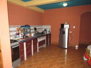 una cucina con piano cottura e frigorifero di Posada Del Viajero - Mayan Travelers Inn a Santa Cruz La Laguna