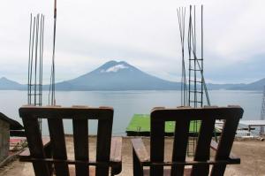 2 sedie sedute di fronte a una vista di montagna di Posada Del Viajero - Mayan Travelers Inn a Santa Cruz La Laguna
