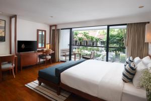 um quarto com uma cama grande e uma janela grande em Woodlands Suites Serviced Residences - SHA Extra Plus em North Pattaya