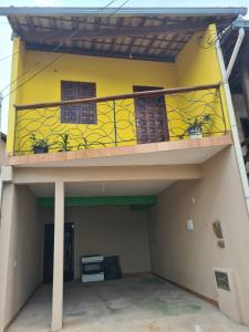 um edifício amarelo com uma varanda com plantas em Casa Diamantina em Lençóis