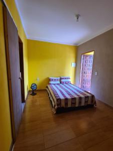 um quarto com uma cama num quarto com paredes amarelas em Casa Diamantina em Lençóis