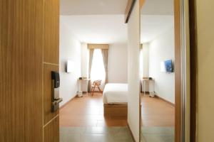 Habitación de hotel con cama y ventana en Sepanak Hotel by Amazing en Curup