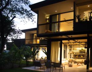 D'Palm Villas في بونتاريناس: منزل مع شرفة مع كراسي وطاولات