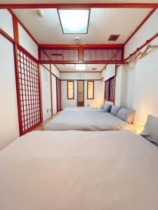 a bedroom with two beds and a skylight at ReA house 心斎橋.島之内 in Osaka