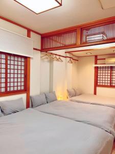 two beds in a room with red and white at ReA house 心斎橋.島之内 in Osaka
