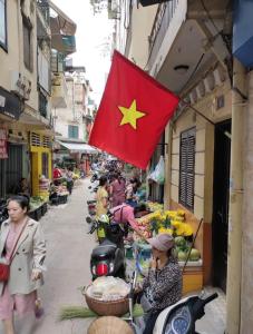a flag is hanging on a building in a market at Golden Moon Suite Hotel in Hanoi