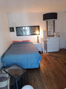 a bedroom with a bed and a table and a lamp at Mini Flat Paris Neuilly La Défense in Neuilly-sur-Seine