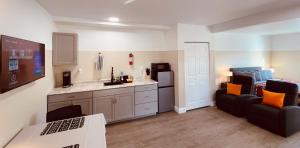 sala de estar con sofá negro y cocina en White Orchid Apartments en Fort Myers