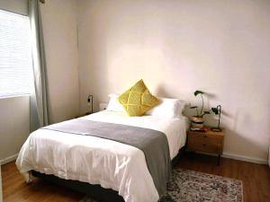 a bedroom with a bed with white sheets and a window at 28 on Ryneveld in Stellenbosch