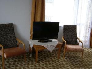 a living room with two chairs and a flat screen tv at Apartment Vysocina in Svratka