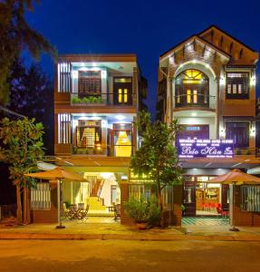 a lit up building with umbrellas in front of it at Phuong Trang Villa Hoi An in Hoi An