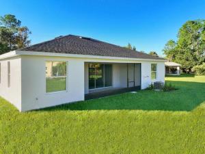 a small white house with a green lawn at Palm Coast Paradise : Cozy 3BR Vacation Retreat in Palm Coast