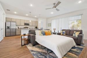 a living room with a large bed and a kitchen at Palm Coast Paradise : Cozy 3BR Vacation Retreat in Palm Coast
