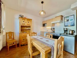 a kitchen with a wooden table and a dining room at Appartement Flumet, 2 pièces, 4 personnes - FR-1-505-202 in Flumet