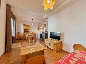 a living room with a couch and a tv and a table at Appartement Flumet, 2 pièces, 4 personnes - FR-1-505-202 in Flumet