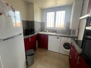 uma cozinha com armários vermelhos e uma máquina de lavar e secar roupa em Appartement Saint-Cyr-sur-Mer, 2 pièces, 4 personnes - FR-1-770-15 em Saint-Cyr-sur-Mer
