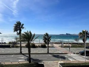 um parque de estacionamento com palmeiras e o oceano em Appartement Saint-Cyr-sur-Mer, 2 pièces, 4 personnes - FR-1-770-15 em Saint-Cyr-sur-Mer