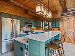 a kitchen with blue cabinets and a large kitchen island at Classic Log Cabin near Rocky Mountain National Park and near Skiing in Lyons