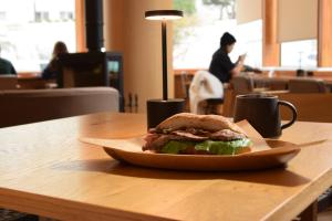 un sándwich en un plato en una mesa en adex Inn, en Noboribetsu