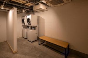 eine Waschküche mit zwei Waschmaschinen und einer Bank in der Unterkunft adex Inn in Noboribetsu