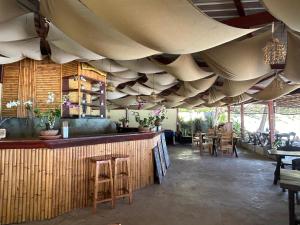restauracja z dużym sufitem ze stołami i krzesłami w obiekcie Apsara & Dragon’s Supra Wellness Resort w mieście Baan Tai