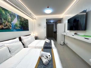 um quarto de hotel com duas camas e uma televisão de ecrã plano em Shore Residences MOA Dynastel Staycation em Manila