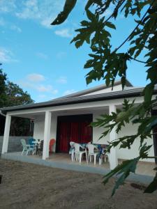 une maison blanche avec des tables et des chaises dans l'établissement Chez Monblanc, à Saint-Joseph