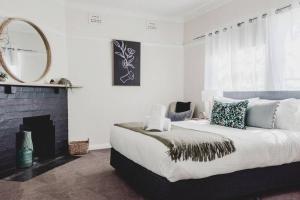 a bedroom with a large bed and a fireplace at Live in the Heart of Mudgee at Fairbairn Cottage in Mudgee