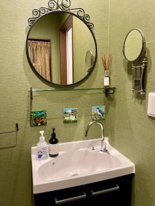 een badkamer met een wastafel en een spiegel bij Kiwi House Tokoname VACATION STAY in Tokoname
