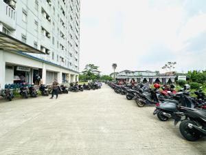 uma fila de motocicletas estacionadas ao lado de um edifício em RedLiving Apartment @ Dramaga Tower by Liana Room em Bubulak 3