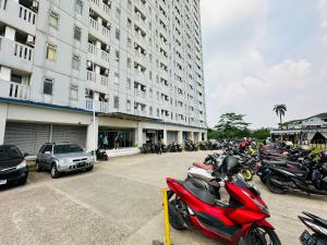 um grupo de motociclos estacionados em frente a um edifício em RedLiving Apartment @ Dramaga Tower by Liana Room em Bubulak 3