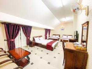 Habitación de hotel con 2 camas y sofá en Duy Thảo 2 hotel en Da Lat