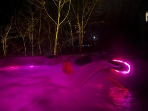 una piscina cubierta de luces rosas por la noche en Auberge musicale Pour un Instant, en La Malbaie