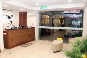 Hotel Seri Putra في كوالالمبور: رجل يجلس في مكتب الاستقبال من متجر