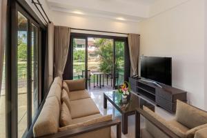 a living room with a couch and a flat screen tv at Banyu Biru Villa in Lagoi