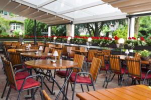 ヒュルトにあるHotel-Restaurant Breitenbacher Hofの木製のテーブルと椅子が置かれた空のレストラン