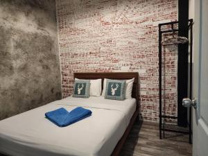 łóżko w pokoju z ceglaną ścianą w obiekcie Baan Minnie 2 bedroom home 400m from Saikaew beach w mieście Ko Samet