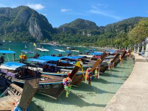 a row of boats docked at a dock in the water at The view Hostel in Phi Phi Islands