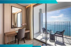 a room with a desk and a balcony with a view at Panorama Nha Trang Signature in Nha Trang
