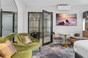 a hotel room with a bed and chairs and a table at St Hugh Hotel Wagga Wagga in Wagga Wagga